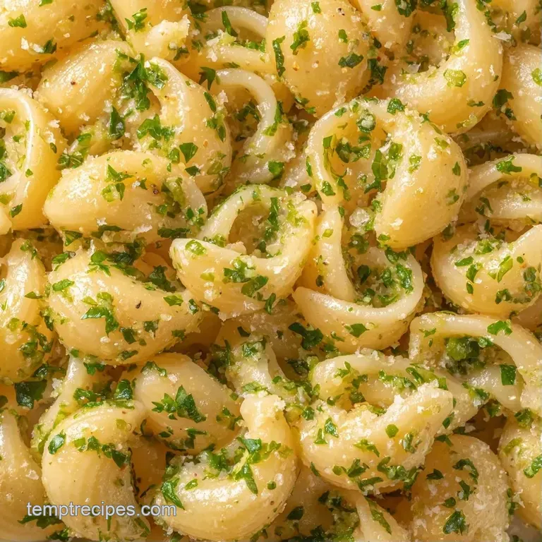 Elegant twirl of glossy pasta in a matte bowl, garnished with bright green herbs and a dusting of cheese.
